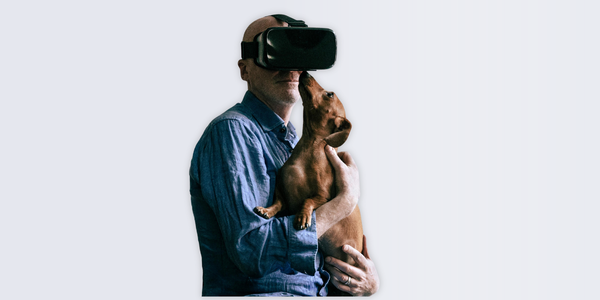 Tim Crouch wearing a VR headset, holding a brown Dachshund